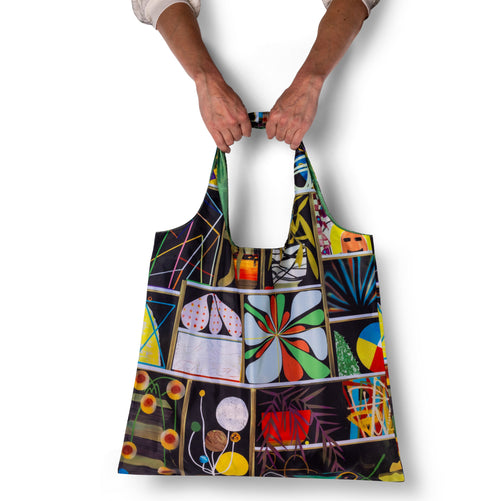 Person holding illustrated collage art tote bag with bold abstract panel print by Paul Wackers for Yellow Owl Workshop