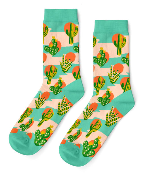 Peach and teal crew socks featuring bold illustrated cacti including saguaro prickly pear and agave with orange desert suns by Yellow Owl Workshop