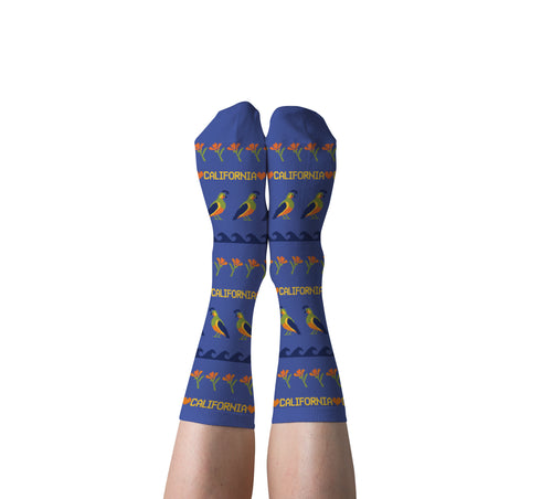 Blue California Quail crew socks with golden poppies and waves worn on feet by Yellow Owl Workshop