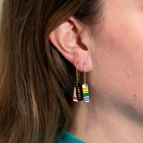 Colors Swatch Book mismatched enamel drop earrings worn on ear by Yellow Owl Workshop