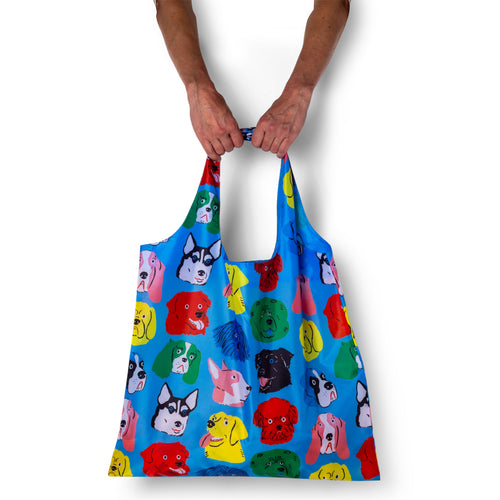Person holding illustrated dog tote bag with colorful playful dog print by Kristina Micotti for Yellow Owl Workshop