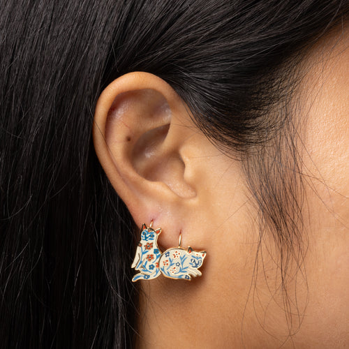 Floral Cat mismatched enamel drop earrings worn on ear by Yellow Owl Workshop