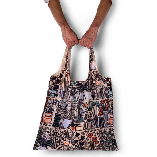Person holding illustrated plant tote bag with colorful potted plant print by Carissa Potter of People I've Loved for Yellow Owl Workshop
