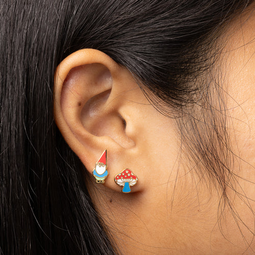 Gnome and Mushroom mismatched gold stud earrings worn on ear by Yellow Owl Workshop