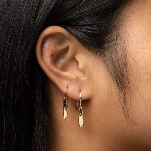 Knife and Cleaver mismatched enamel drop earrings worn on ear by Yellow Owl Workshop