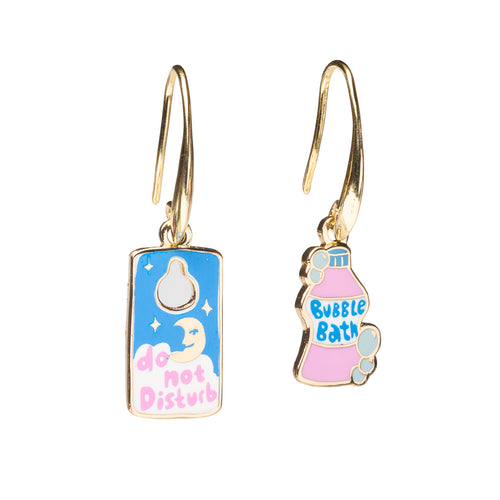 Mismatched enamel drop earrings featuring Do Not Disturb door hanger with moon and stars and pink bubble bath bottle by Yellow Owl Workshop