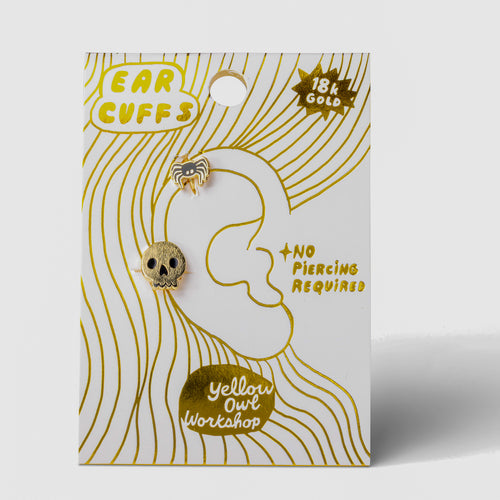 Skull and Spider no-piercing gold ear cuffs on gold foil matchbook card by Yellow Owl Workshop