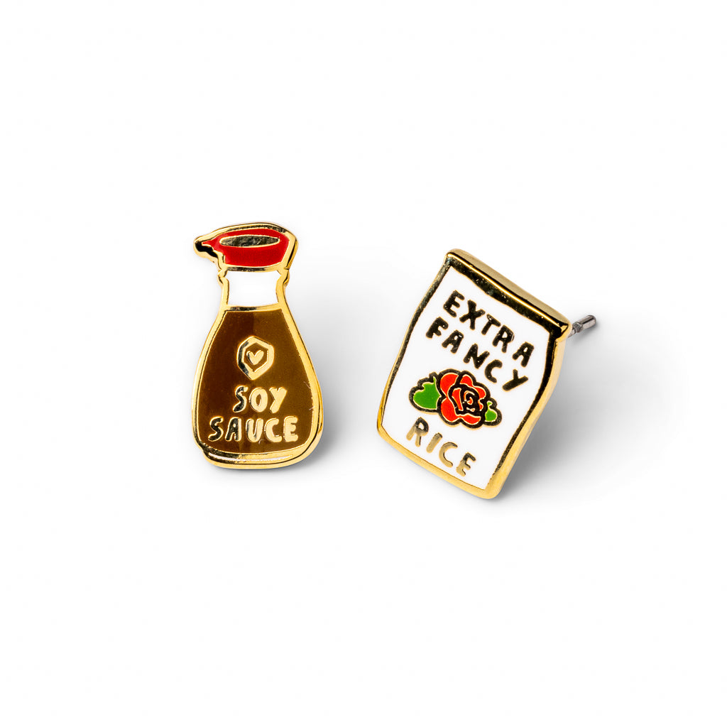 Mismatched cloisonné stud earrings featuring soy sauce pour bottle and Extra Fancy rice bag gilded in 22 karat gold by Yellow Owl Workshop