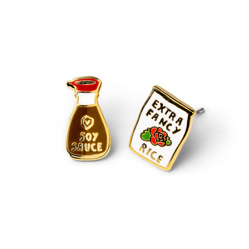 Mismatched cloisonné stud earrings featuring soy sauce pour bottle and Extra Fancy rice bag gilded in 22 karat gold by Yellow Owl Workshop