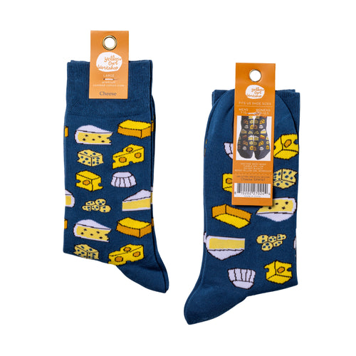 Yellow Owl Workshop men's cheese crew socks in navy blue with a colorful pattern of cheddar, Swiss, brie, blue cheese, and other cheese varieties. Soft combed cotton socks shown with front and back product packaging, featuring a fun cheese-themed design for food lovers.