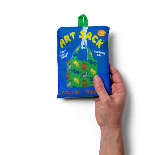 Person holding green illustrated reusable tote bag with colorful wildcat print by Kristina Micotti for Yellow Owl Workshop