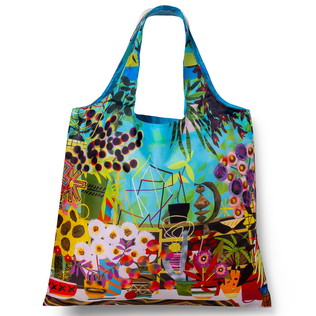 Illustrated reusable tote bag featuring surreal colorful vegetable landscape and bookshelf collage art by Paul Wackers for Yellow Owl Workshop