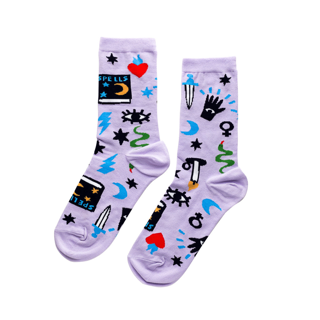Lavender crew socks featuring illustrated mystic symbols including spell book all-seeing eye crescent moon dagger and snake by Yellow Owl Workshop