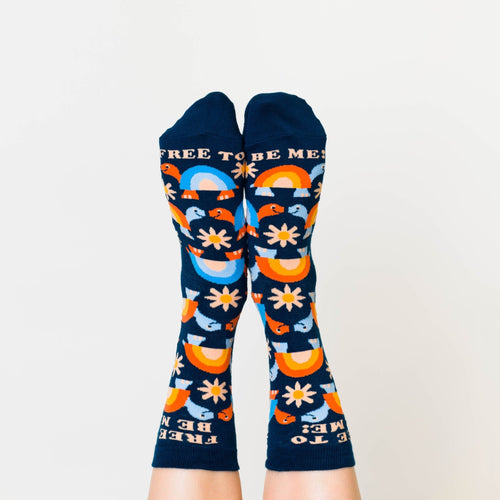 Navy Free to Be Me crew socks with turtle rainbow and daisy print worn on feet by Yellow Owl Workshop