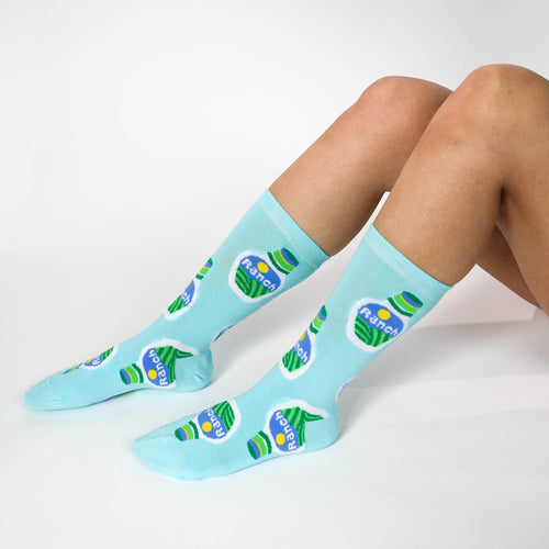 Light blue Ranch crew socks with illustrated ranch dressing bottle print worn on feet by Yellow Owl Workshop