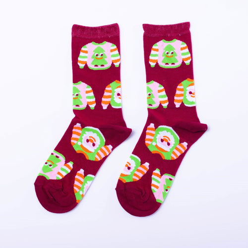 Red crew socks featuring illustrated ugly Christmas sweaters with Christmas trees and orange green stripes by Yellow Owl Workshop