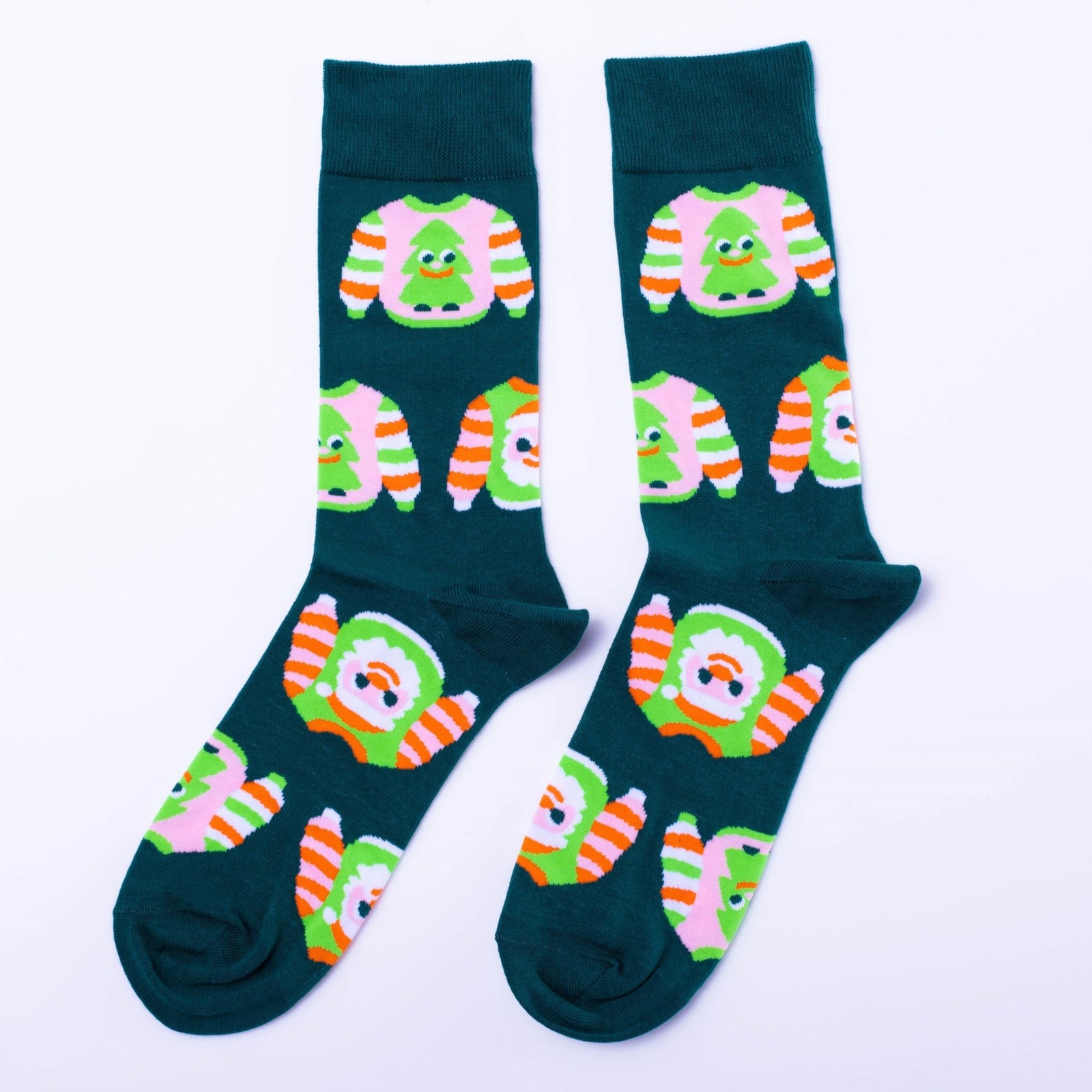 Teal crew socks featuring illustrated ugly Christmas sweaters with Christmas trees and orange green stripes by Yellow Owl Workshop