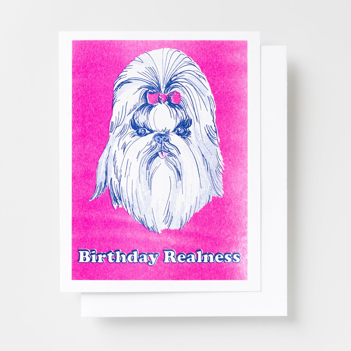 Risograph greeting card with a glamorous Shih Tzu wearing pink bows on a hot pink background, text reads Birthday Realness in bold white and blue lettering