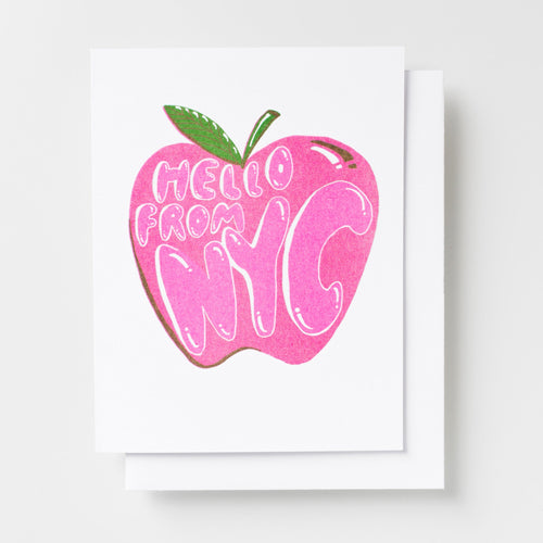 Risograph greeting card with a bold pink illustrated apple with text reading Hello From NYC in white bubble lettering with a green leaf stem on a white background